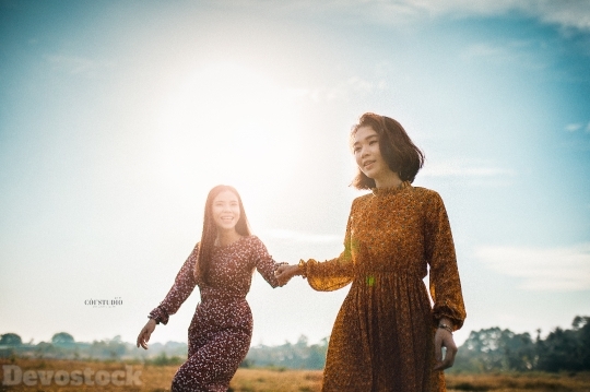 Devostock Beautiful Two Women GRASS HOLDING HANDS Sisterhood 4k