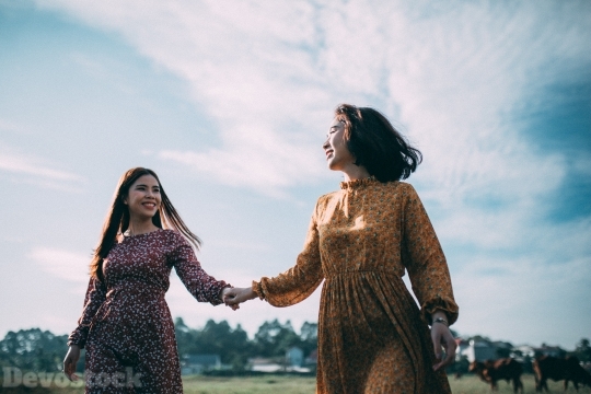 Devostock Beautiful Two Women GRASS HOLDING Smiling HANDS Sisterhood 4k