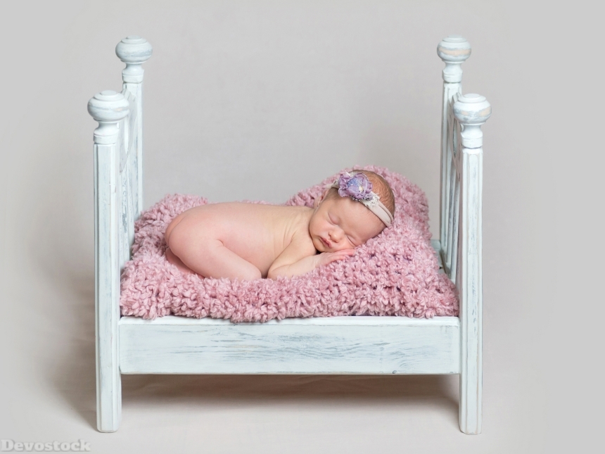 Devostock Lovely newborn baby girl sleeps on the crib