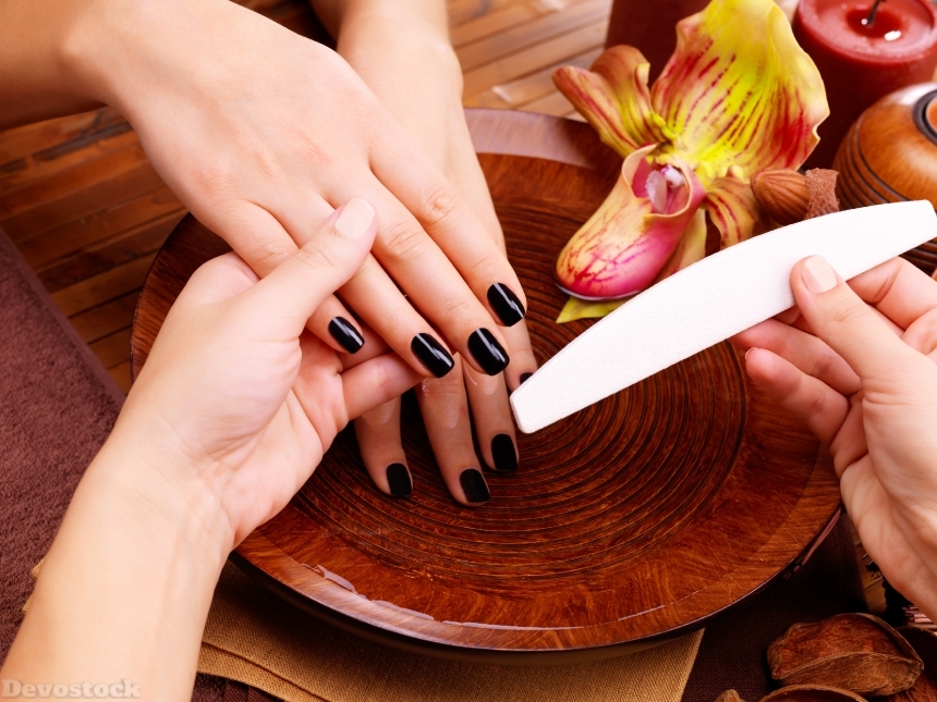 Devostock Manicurist master  makes manicure on woman_qt_s hands