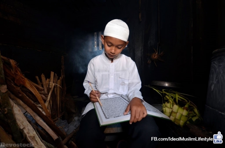 Devostock A Muslim boy reading Al Quran