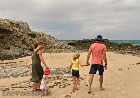 Devostock Family walking on the sand of the beach