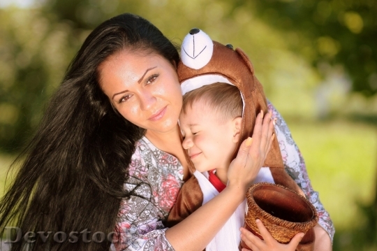 Devostock Little boy wearing bear costume hugging his mom