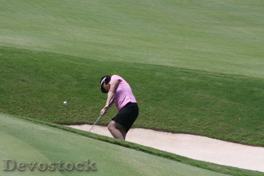 Devostock Young Woman Golfer Chipping