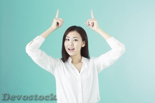 Devostock Beautiful Girl Japanese Pointing Up Both Hands