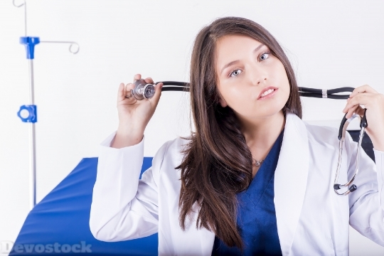 Devostock FEMALE DOCTOR TRYING TO HANG A STETHOSCOPE ON THE NECK
