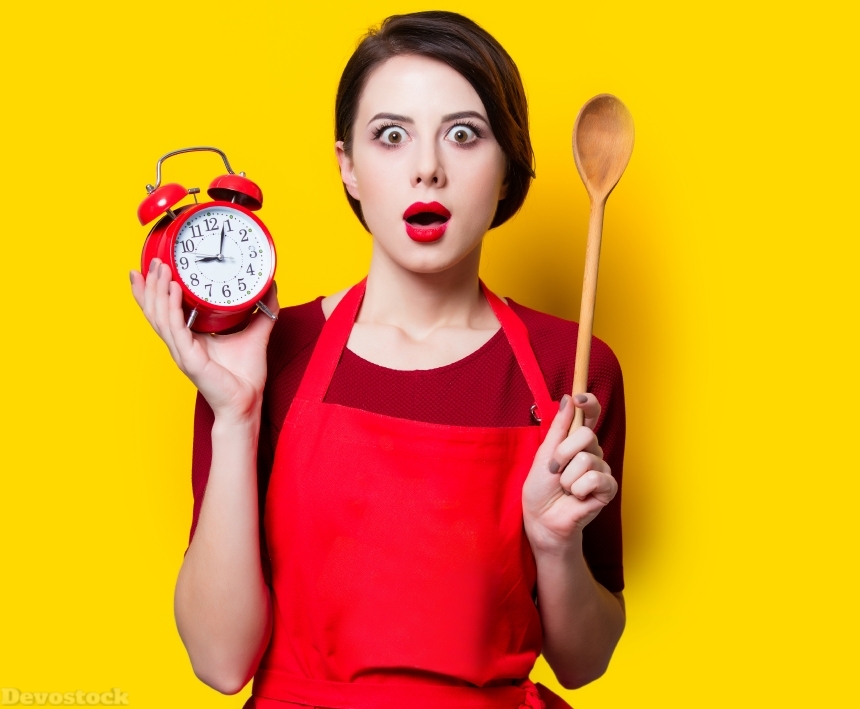 Devostock  housewife with red alarm clock and spoon 