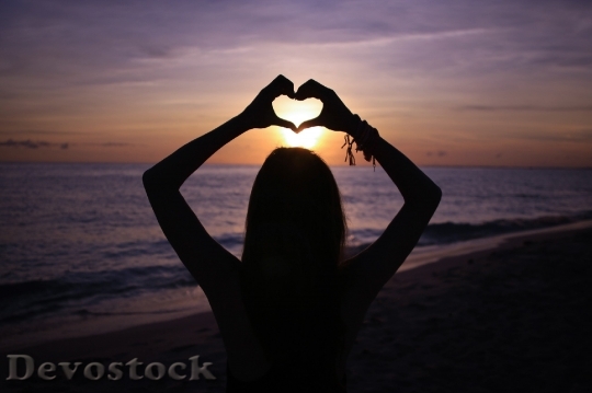 Devostock A girl showing a heart sign by her hands