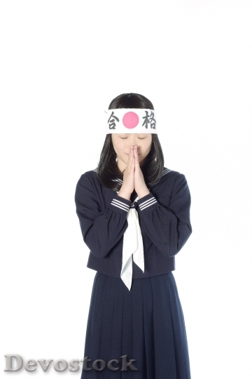 Devostock A Japanese school girl who prays for passing the examination