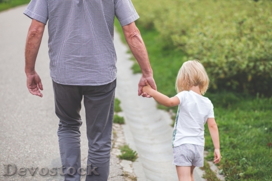 Devostock A little girl walking with her dad