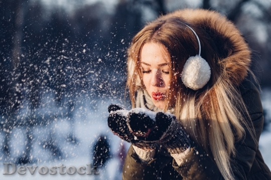 Devostock Adult Beautiful girl Blowing Snow