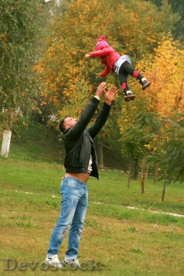 Devostock Father throwing his little girl in the air