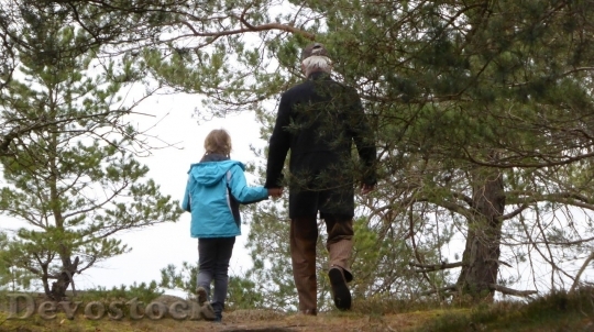 Devostock Girl walking with her dad in the woods