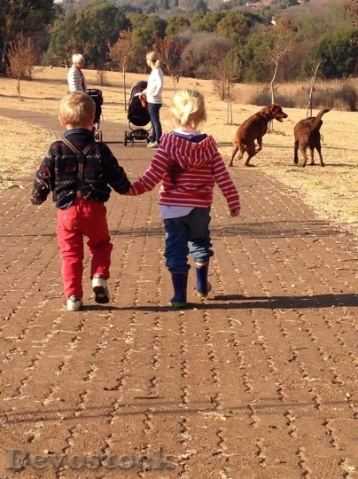 Devostock Little boy and girl walking in the park