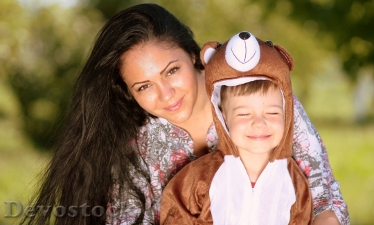 Devostock Little boy wearing bear costume with close eyes and his mom