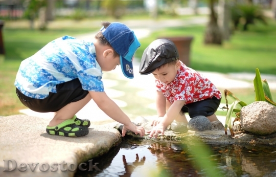 Devostock Little boys playing with water of the lake