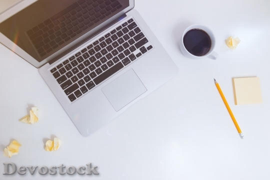 Devostock White desk with notes, coffee and laptop