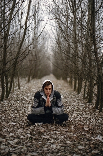 Devostock White man meditating in the forest and holding hands
