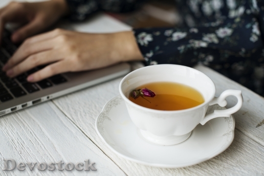Devostock Woman working and a hot cup of floral tea