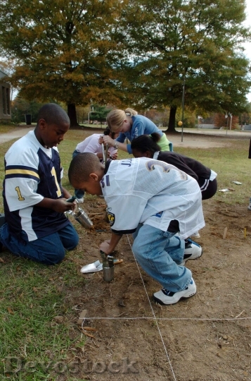 Devostock Children Digging Holes To
