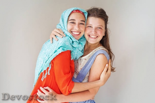 Devostock muslim-and-christian-girl-hugging-each-other-pictu$1